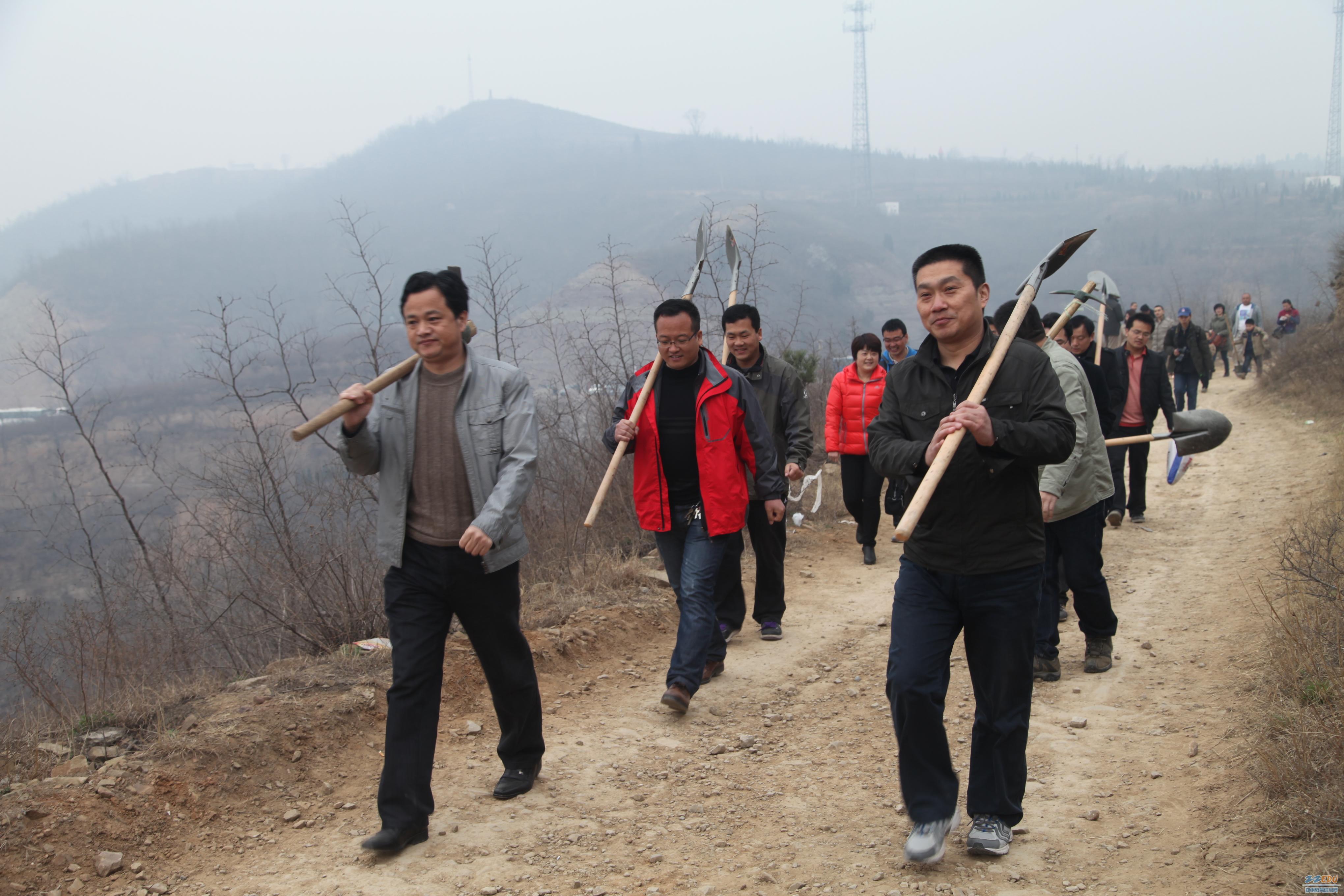 志愿者队伍在朱红军校长的带领下扛着铁锹,迈着矫健的步伐向植树地点