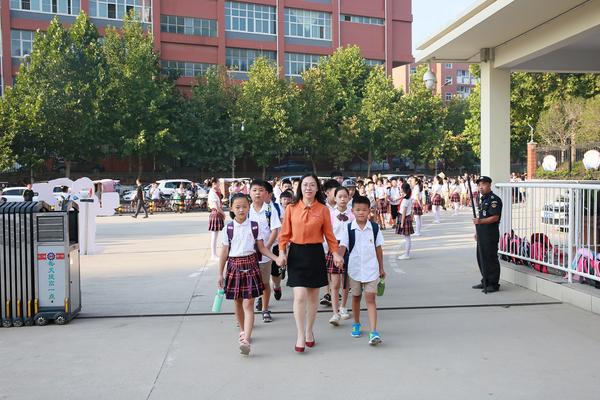 郑州经开区实验小学校长史兆霞和孩子们牵手入校
