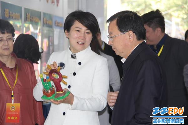 园长郝江玉向市政协副主席王万鹏展示孩子们