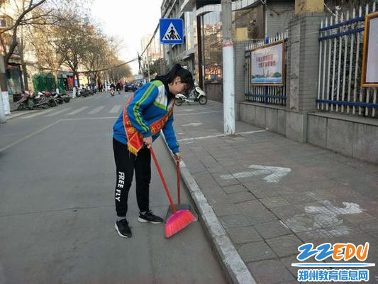 拿着扫把、簸箕打扫路面卫生 拿着扫把、簸箕打扫路面卫生