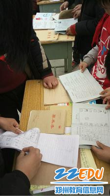 孩子们在翻看寒假素质手册和预习作业 孩子们在翻看寒假素质手册和预习作业