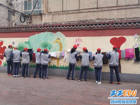 5、志愿者把衣服分类整理并把悬挂在爱心墙上 5、志愿者把衣服分类整理并把悬挂在爱心墙上
