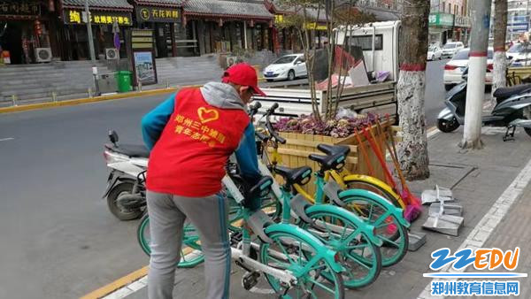 志愿者在认真摆放共享单车 志愿者在认真摆放共享单车