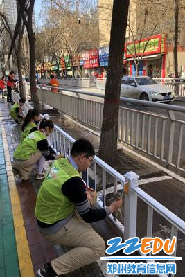 “小路长”们拿着抹布认真擦拭人行道内侧的护栏。 “小路长”们拿着抹布认真擦拭人行道内侧的护栏。