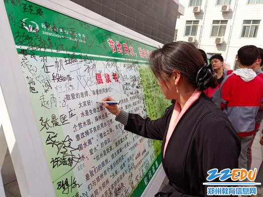 师生们在节水倡议书上签名 师生们在节水倡议书上签名