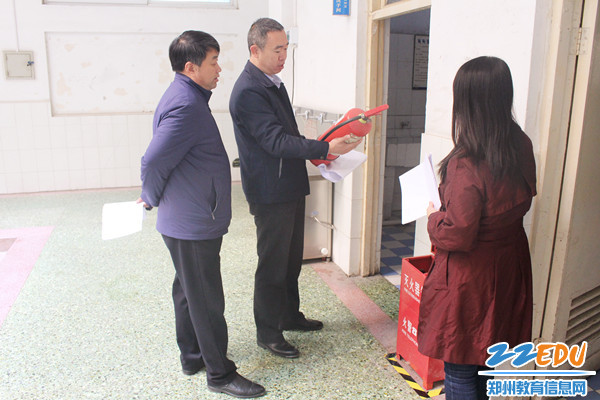 马校长认真检查灭火器_副本 马校长认真检查灭火器_副本