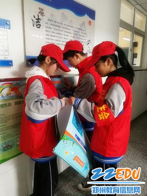 5志愿者在教学楼粘贴宣传海报 5志愿者在教学楼粘贴宣传海报