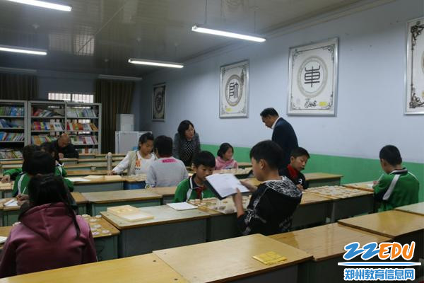 荥阳市象棋中心的两位老师在指导象棋小选手对弈