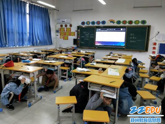 2学生在桌下用手护住头部