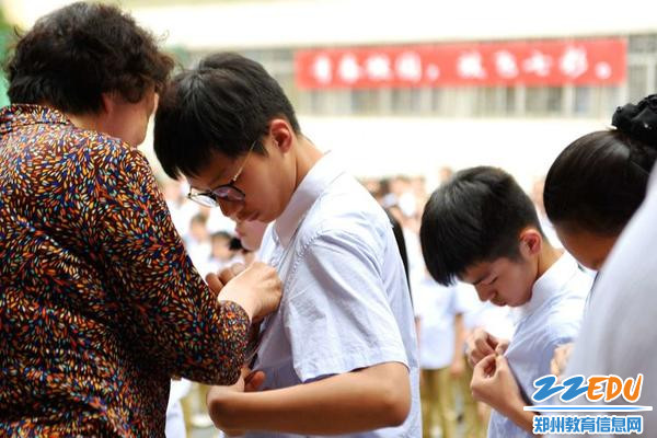 7.经纬中学副校长江俊英为新团员佩戴团徽 7.经纬中学副校长江俊英为新团员佩戴团徽