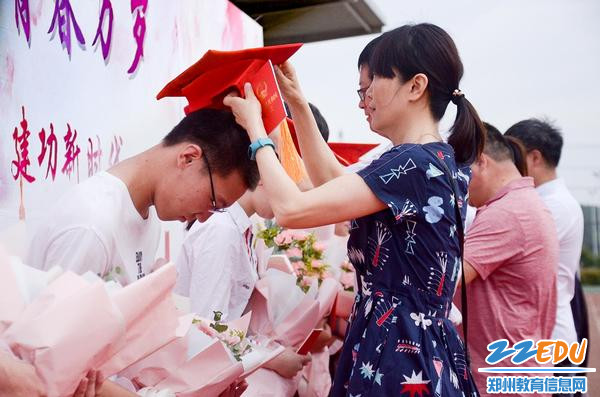 老师为学生配戴成人帽