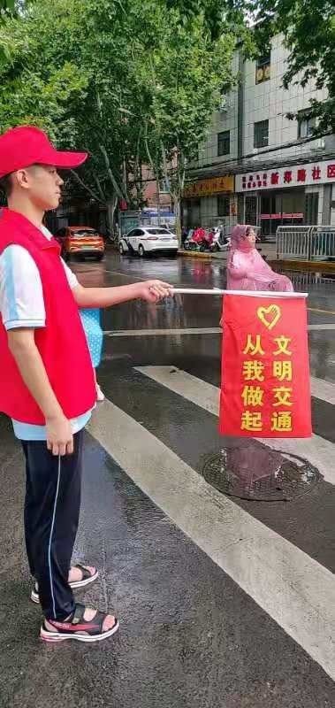 学生志愿者雨中交通执勤 郑州五中助力全国少数民族运动会