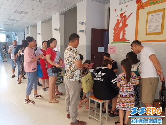 报名处家长在老师指导下认真填写报名材料_调整大小 报名处家长在老师指导下认真填写报名材料_调整大小