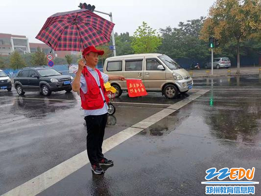 4+秋雨绵绵淫雨霏霏中志愿者一手拿伞一手举旗，所有行人车辆听我的，动作标准吧