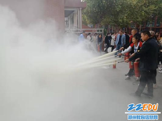 家长使用灭火器进行灭火演练 家长使用灭火器进行灭火演练