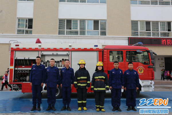 学生身穿消防服与消防队员合影 学生身穿消防服与消防队员合影