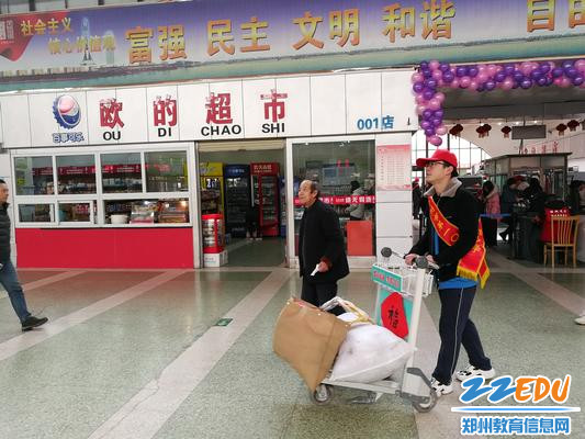 志愿者帮助旅客推行李 志愿者帮助旅客推行李