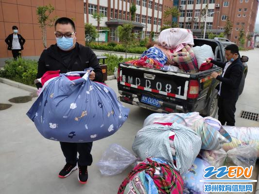 郑州57中宋金营老师和王肖老师做复学学生行李“搬运工”