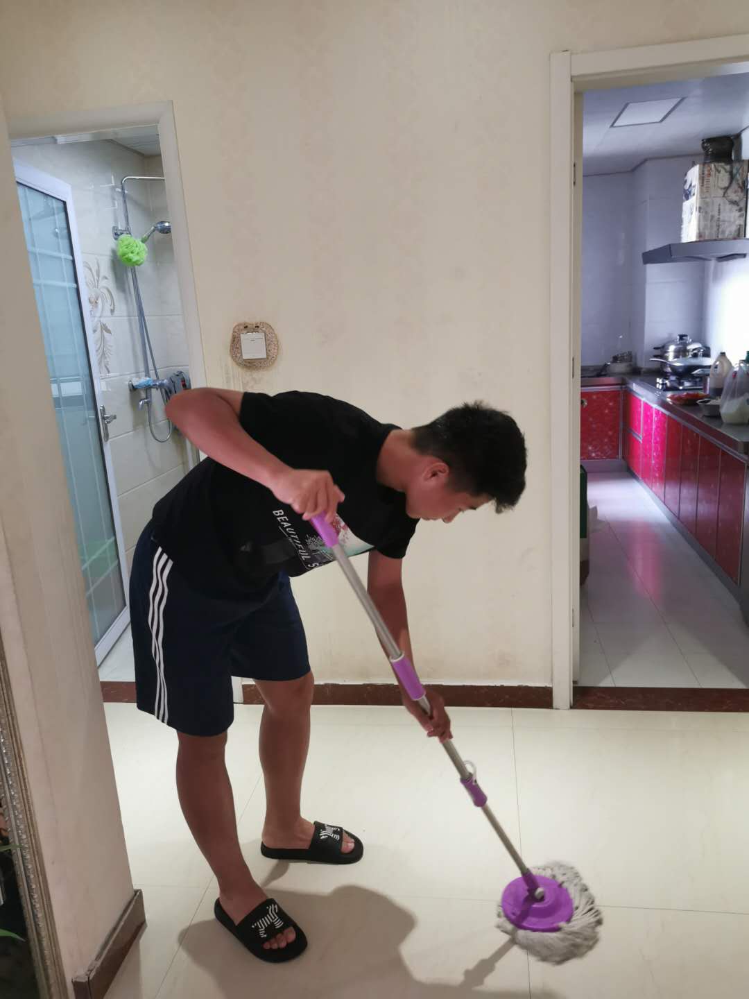 男孩在房间里打扫地板。男孩帮助妈妈打扫卫生。照片摄影图片_ID:300228429-Veer图库