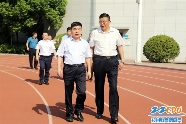 2郑州市第十九高级中学党委书记、校长梁寅峰（右）陪同二七区区长苏建设（左）参观校园_副本