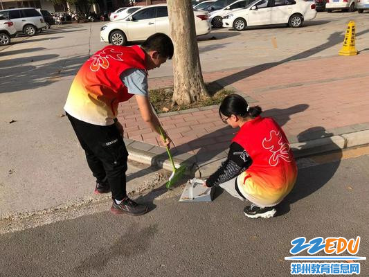 学生志愿者为社区道路清扫垃圾