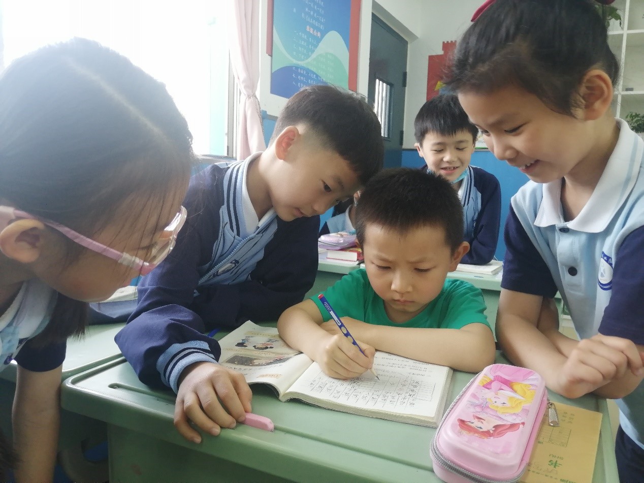 一年级的同学们教小朋友们读书,写字