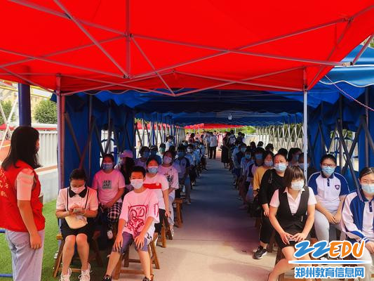 3  2021年8月19日郑州42中学生和家长在疫苗接种点等候区有序等候