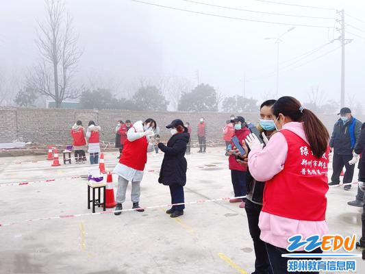 郑东新区普惠路第一幼儿园教师志愿者在进行扫码登记核酸检测工作