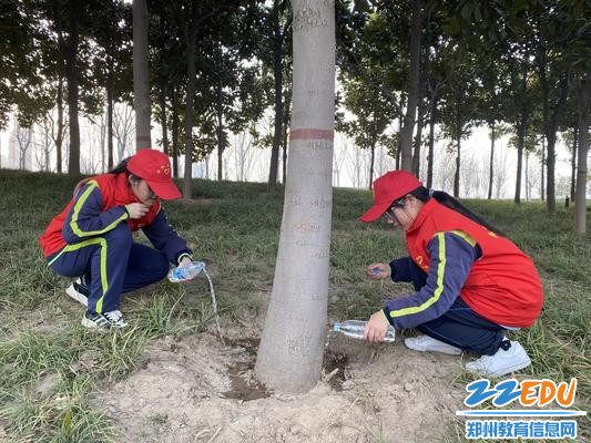 3志愿者用自己的水杯给树木浇水