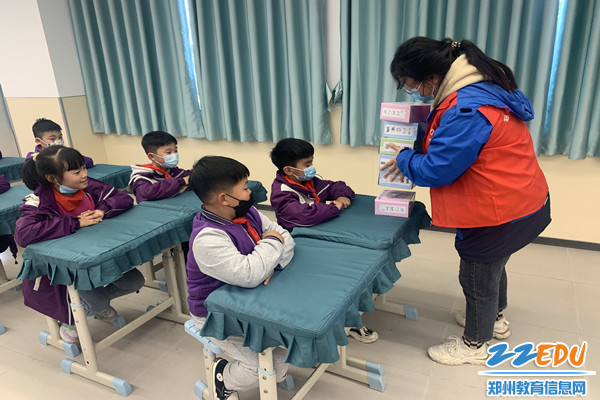 郑州市商贸管理学校青年志愿者为学生们发放模型_副本 郑州市商贸管理学校青年志愿者为学生们发放模型_副本