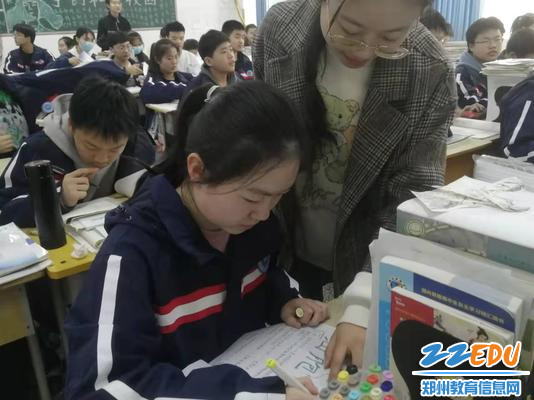 课余时间老师指导学生制作手抄报