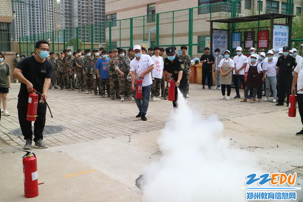 学生处主任郑丹带领参练人员为同学们展示灭火器使用方法