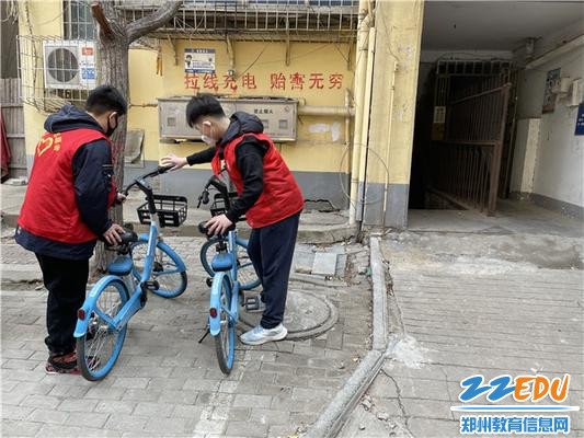 2志愿者正在摆放共享单车