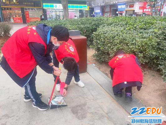 团员志愿者清理花丛中杂物 团员志愿者清理花丛中杂物