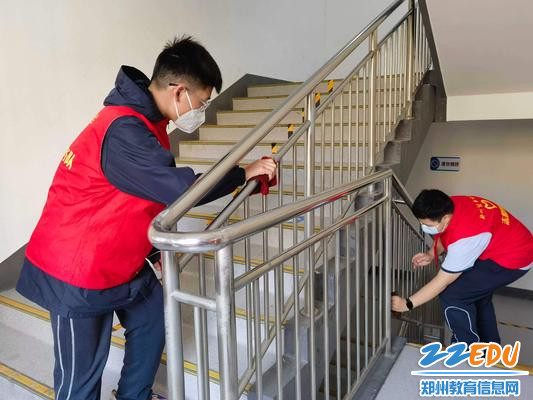 学生志愿者擦拭楼梯栏杆 学生志愿者擦拭楼梯栏杆
