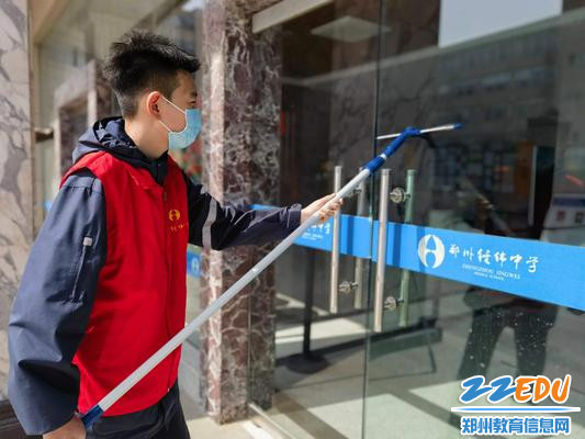 学生志愿者擦拭教学楼玻璃 学生志愿者擦拭教学楼玻璃