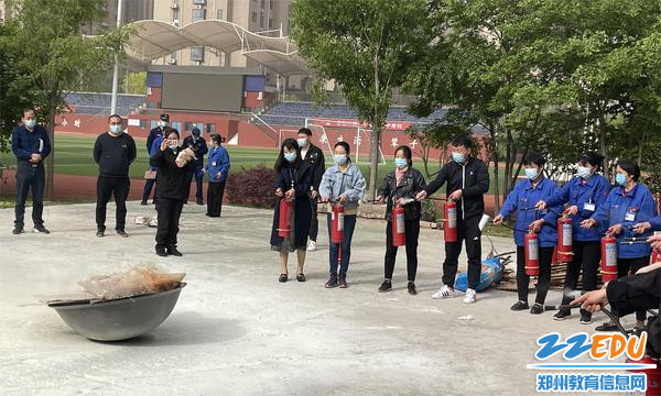 总务处、政教处人员和物业人员同组实操演练正确使用灭火器 总务处、政教处人员和物业人员同组实操演练正确使用灭火器