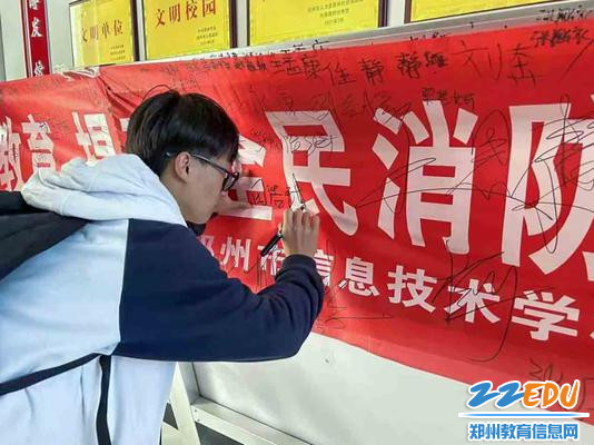 1学生在关于消防安全条幅上签字 1学生在关于消防安全条幅上签字