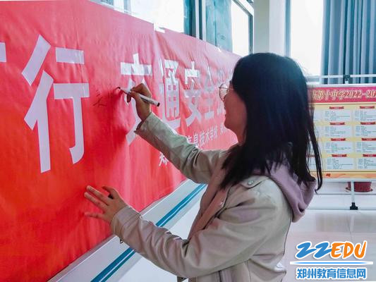 2教师在交通安全条幅上签字。 2教师在交通安全条幅上签字。