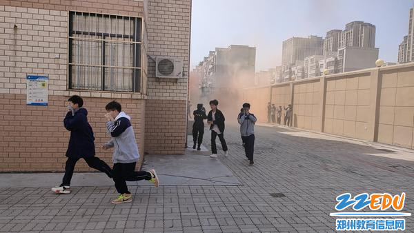 学生们在执勤老师引导下有序逃离“火场” 学生们在执勤老师引导下有序逃离“火场”