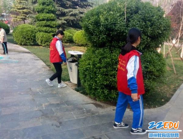 志愿者用捡拾垃圾活动宣传文明旅游中不要随意扔垃圾