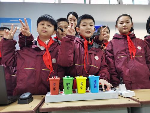 郑州市郑东新区昆丽河小学学生展示他们发明的带有语音识别功能的“智能垃圾桶”