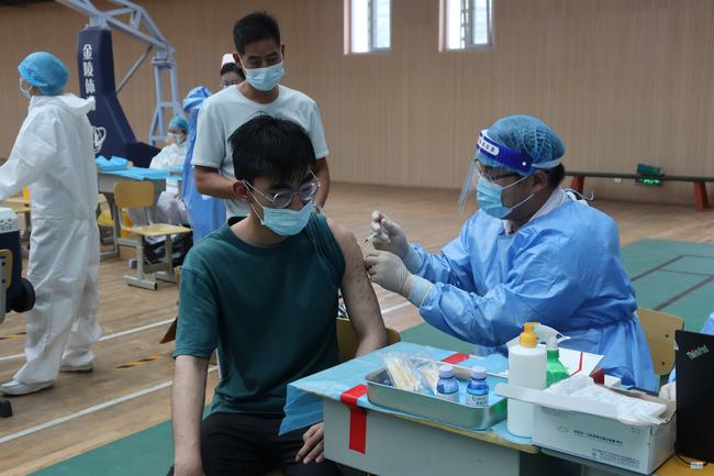 4医务人员为学生接种新冠疫苗