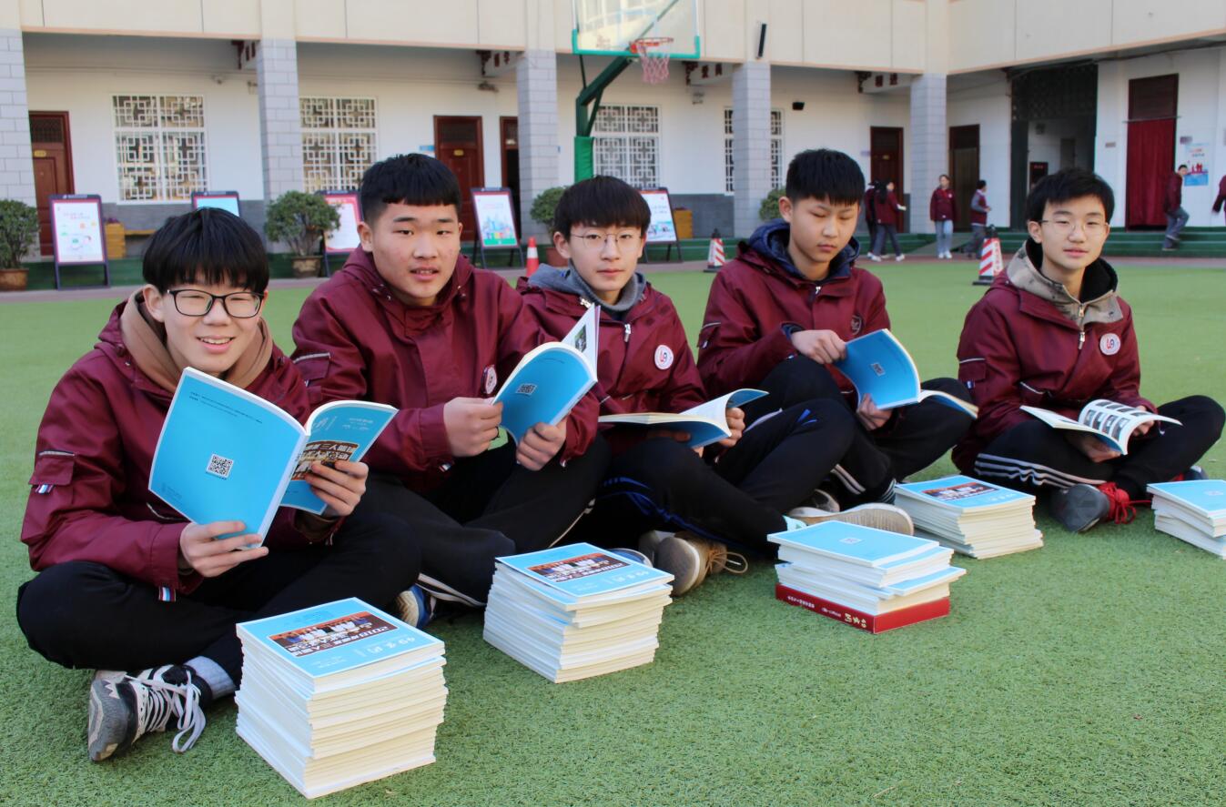 学生迫不及待地翻阅《四九家园》,分享成长的故事.