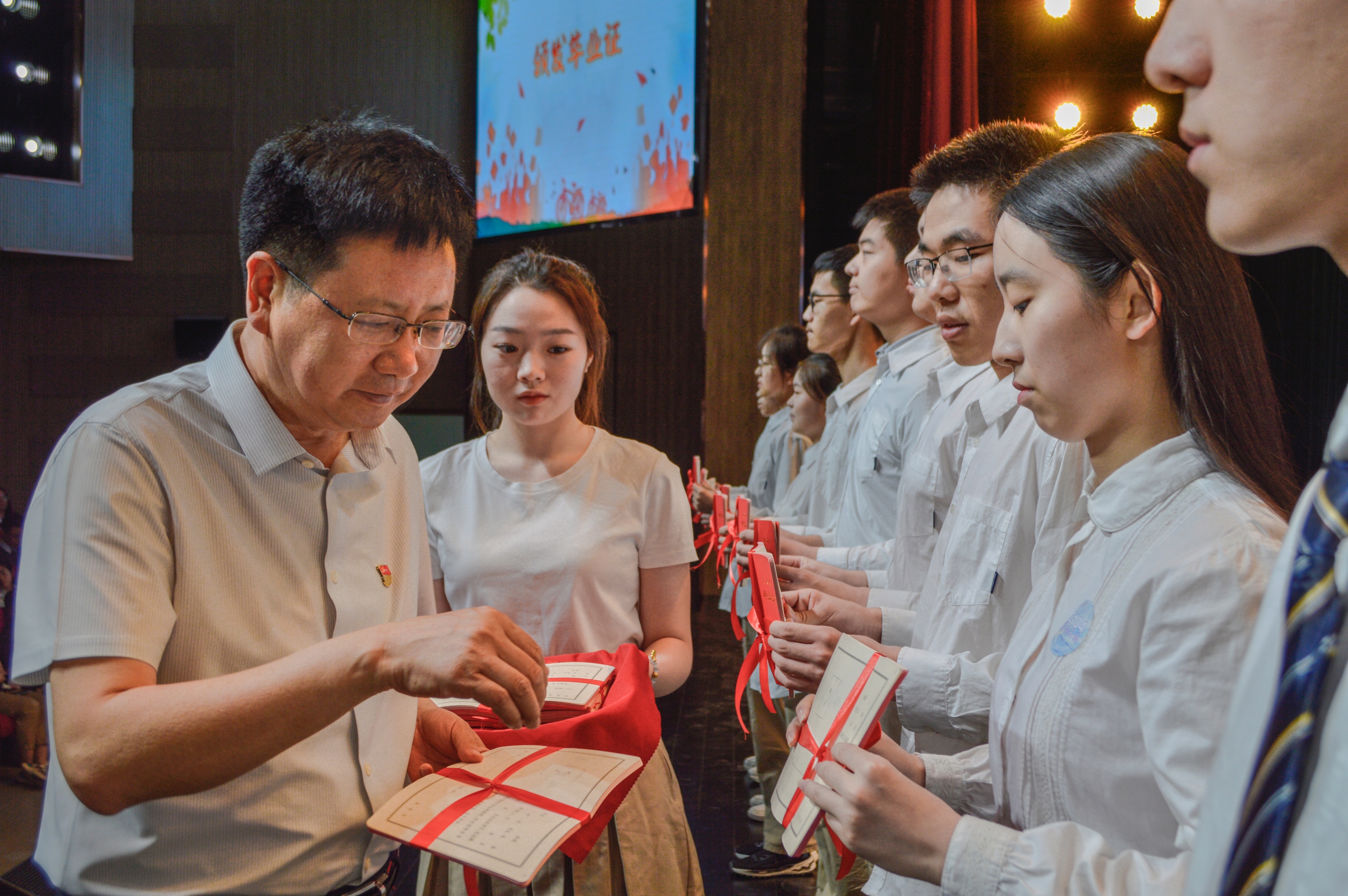 高校长为学生颁发毕业证书