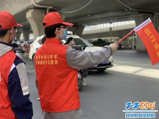 志愿者们手持小红旗认真进行文明交通服务