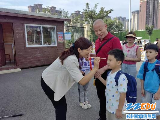 郑州航空护航路路小学副校长胡苗苗为孩子点朱砂启智 (2)